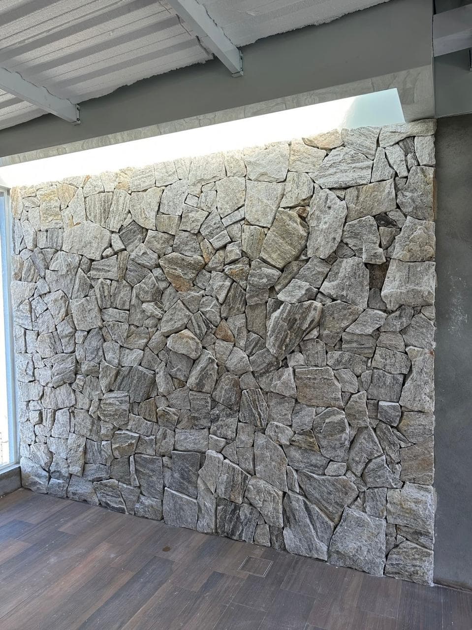 Painel claro de pedra natural instalado em ambiente coberto